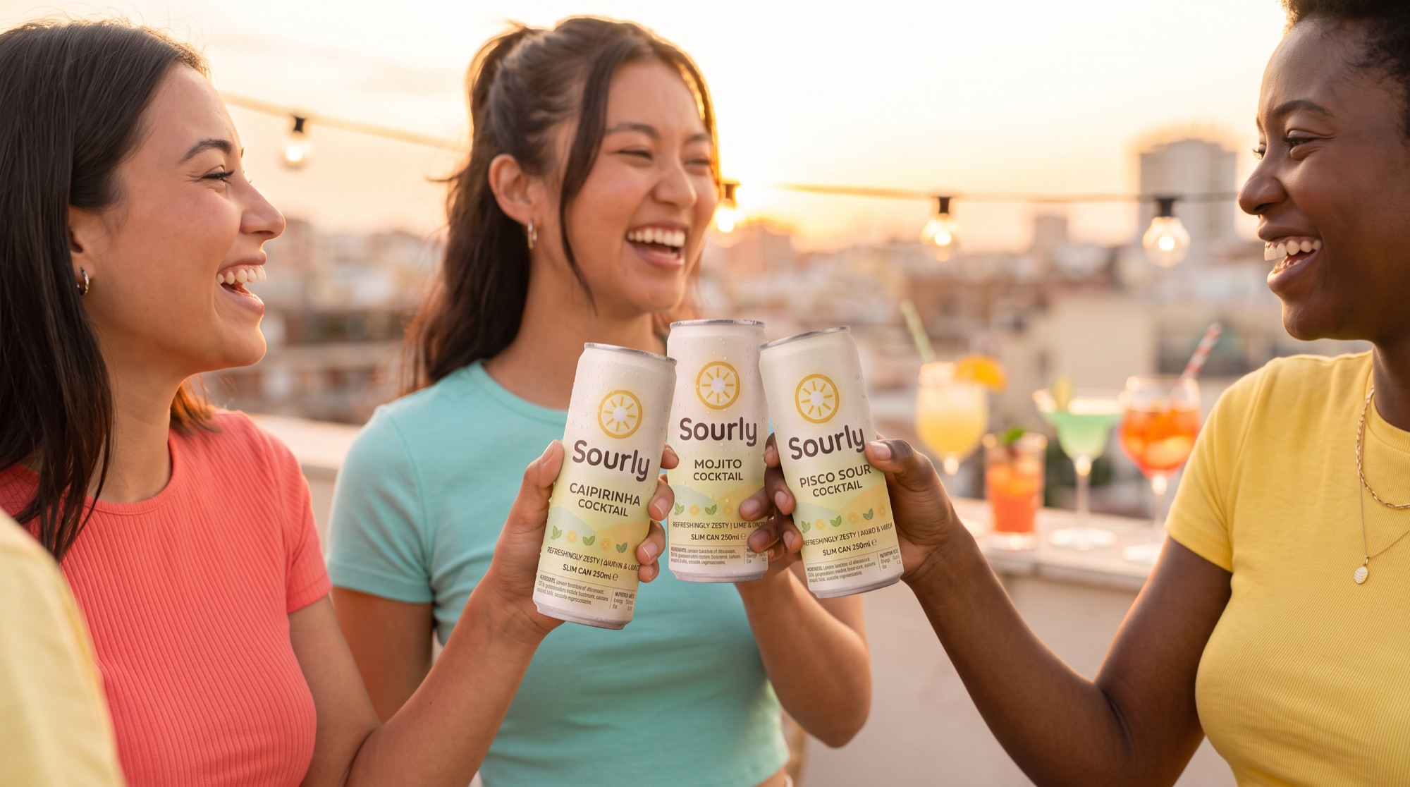 Friends toasting with Sourly cans at golden hour